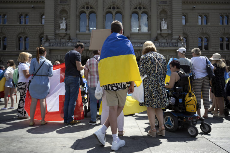 Participants protest in support of Ukraine just after the broadcast of the Ukrainian President Volodymyr Zelensky's speech to the members of the Swiss parliament, front of the Federal Palace, in Bern, Switzerland, Thursday, June 15, 2023. (KEYSTONE/Anthony Anex)