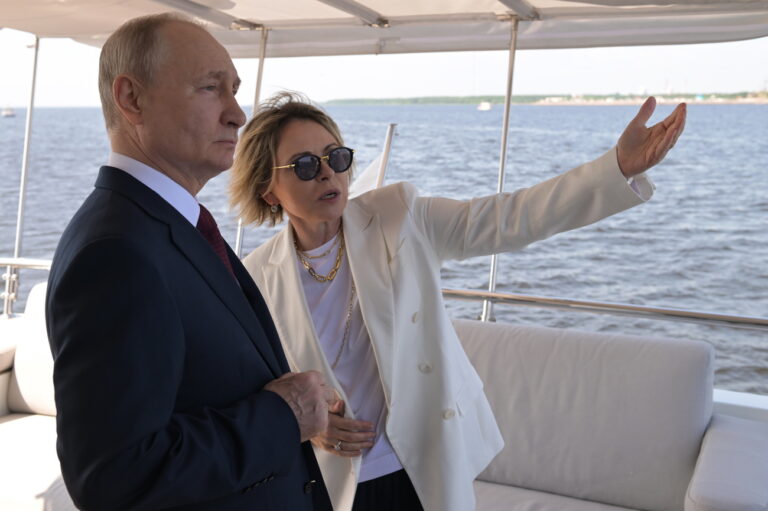 epa10696997 Russian President Vladimir Putin (L) and Deputy Director General of Gazprom Neft, Lakhta Center Director General Yelena Ilyukhina are seen on board the Okhta yacht in the Gulf of Finland during a ceremony to raise state flags held by Gazprom on the coastline near the park of the 300th anniversary of St. Petersburg, Russia, 17 June 2023. The flags of Russia, the USSR, and the Russian Empire have been raised during the ceremony. EPA/PAVEL LISITSYN/SPUTNIK/KREMLIN POOL