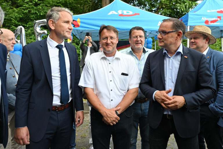 25.06.2023, Thüringen, Sonneberg: Björn Höcke (l), Robert Sesselmann (M), Stephan Brandner (3.v.l.) und Tino Chrupalla stehen im Graten des Restaurants Frankenbaude bei der AfD-Wahlparty. Der ehemalige Landrat Hans-Peter Schmitz (parteilos) war aufgrund einer langwierigen Erkrankung in den Ruhestand versetzt worden. Der AfD-Abgeordnete Robert Sesselmann hatte in der ersten Runde die meisten Stimmen erhalten. Er wäre der erste AfD-Landrat in Deutschland. In der Stichwahl tritt er gegen Jürgen Köpper (CDU) an. Foto: Martin Schutt/dpa +++ dpa-Bildfunk +++ (KEYSTONE/DPA/Martin Schutt)