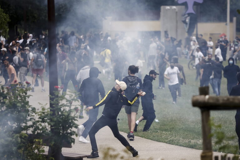 epa10717676 A protester throws a rock during clashes with French riot police following a march in the memory of 17-year-old Nahel, who was killed by French Police in Nanterre, near Paris, France, 29 June 2023. Violence broke out after the police fatally shot a 17-year-old during a traffic stop in Nanterre on 27 June. According to the French interior minister, 31 people were arrested with 2,000 officers being deployed to prevent further violence. EPA/YOAN VALAT