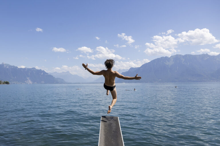 A man dives into the lake and enjoy the warm summer weather on the shores of Lake Geneva in front of the Swiss Alps mountains, in Vevey, Switzerland, Saturday, July 8, 2023 (KEYSTONE/Cyril Zingaro)