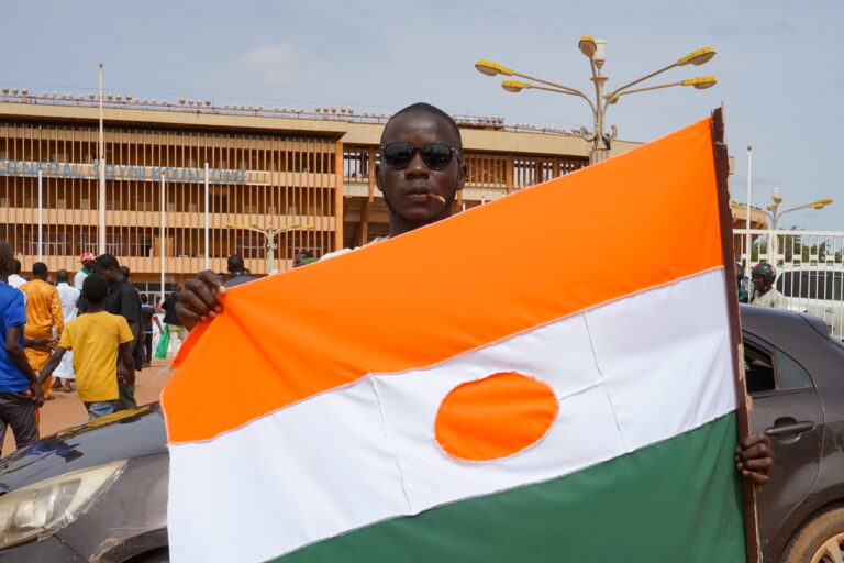 epa10788176 A man displays a Niger flag on his way to a rally in a stadium in Niamey, Niger, 06 August 2023. Thousands of pro-junta supporters gathered in a stadium to show their support for the military coup ahead of the deadline given by the Economic Community of West African States, (ECOWAS), to free and reinstate democratically elected President Mohamed Bazoum. EPA/ISSIFOU DJIBO