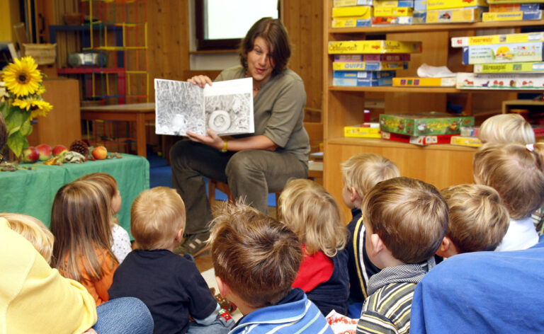 Eine Erzieherin liest am Freitag, 26 Sept. 2008, Kindern in einem Kindergarten bei Heidelberg aus einem Buch vor. Gegen die Stimmen der Opposition hat der Bundestag am Freitag das Kinderfoerderungsgesetz verabschiedet. Es verschafft unter Dreijaehrigen von 2013 an einen Rechtsanspruch auf einen Platz in der Krippe oder bei einer Tagesmutter. Familienministerin Ursula von der Leyen sprach von einem Meilenstein fuer mehr Vereinbarkeit von Familie und Beruf und mehr Bildung. (AP Photo/Daniel Roland) ** zu APD1338 ** --- A nursery teacher reads a book to children in a Kindergarten near Heidelberg, on Friday, Sept. 26, 2008. (AP Photo/Daniel Roland)