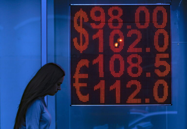 epa10800117 A woman walks past an exchange office with an electronic panel displaying currency exchange rates for US dollar and Euro against Russian ruble in Moscow, Russia, 14 August 2023. The Russian ruble fell to its lowest value in 16 months, past 100 rubles per US dollar. EPA/SERGEI ILNITSKY