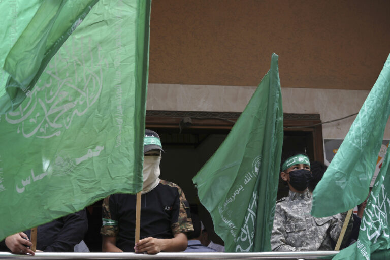 Masked militants from the Izzedine al-Qassam Brigades, the military wing of Hamas, wave the green flags of the Islamist group during a protest in support of Palestinian prisoners in Israeli jails, after Friday prayer in Nusseirat refugee camp, central Gaza Strip, Friday, Aug. 18, 2023. A thousand prisoners in Israeli jails started a mass hunger strike Friday in protest over harsh new Israeli prison measures. (AP Photo/Adel Hana)