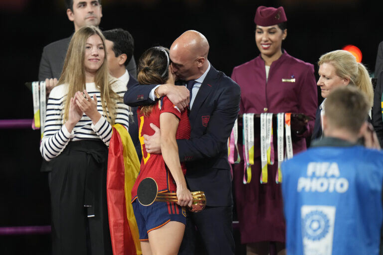 President of Spain's soccer federation, Luis Rubiales, right, hugs Spain's Aitana Bonmati on the podium following Spain's win in the final of Women's World Cup soccer against England at Stadium Australia in Sydney, Australia, Sunday, Aug. 20, 2023. At left is Spain's Princess Infanta Sofia. (AP Photo/Alessandra Tarantino)