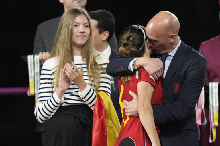 President of Spain's soccer federation, Luis Rubiales, right, hugs Spain's Aitana Bonmati on the podium following Spain's win in the final of Women's World Cup soccer against England at Stadium Australia in Sydney, Australia, Sunday, Aug. 20, 2023. At left is Spain's Princess Infanta Sofia. (AP Photo/Alessandra Tarantino)