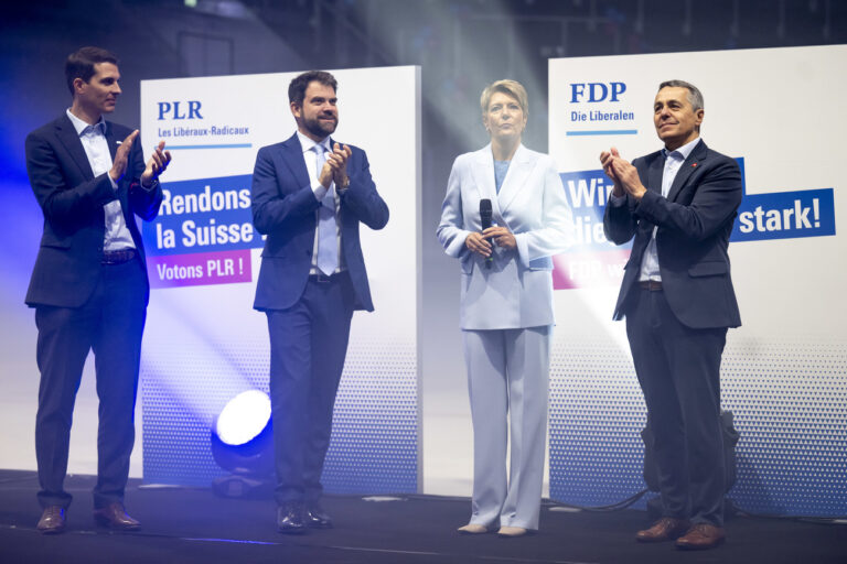 De gauche a droite, le president du PLR Suisse et conseiller aux Etats Thierry Burkart, le president du groupe liberal-radical et conseiller national Damien Cottier, le conseiller federal Ignazio Cassis applaudissent la conseillere federale Karin Keller-Sutter, deuxieme depuis la droite, pour son travail lors du rachat du Credit Suisse par l'UBS lors de la journee du PLR et phase clef de la campagne des elections federales du parti PLR Les Liberaux-Radicaux suisse ce samedi 2 septembre 2023 a la patinoire de la BCF Arena a Fribourg. (KEYSTONE/Laurent Gillieron)