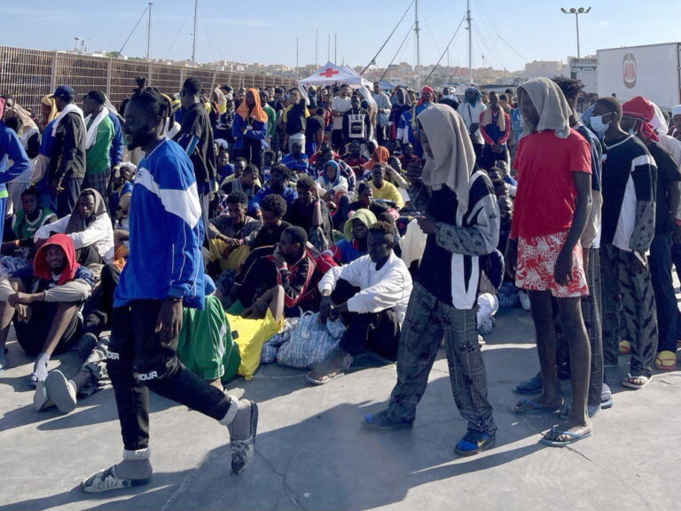 epa10858123 A group of migrants wait on the island of Lampedusa as Italian authorities prepare for transferring people following new arrivals, Italy, 13 September 2023. More than 6,790 migrants were on the Italian island on 13 September after a record arrival of 6,402 people in two days. The Prefecture of Agrigento has arranged for a ferry to pick up around 700 people from Lampedusa to Porto Empedocle, while another 180 being transferred by an IOM flight. EPA/ELIO DESIDERIO