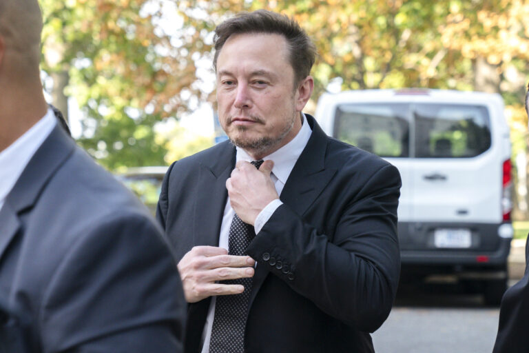 Elon Musk, CEO of X, the company formerly known as Twitter, tightens his tie as he arrives for a closed-door gathering of leading tech CEOs to discuss the priorities and risks surrounding artificial intelligence and how it should be regulated, at Capitol Hill in Washington, Wednesday, Sept. 13, 2023.(AP Photo/Jacquelyn Martin)