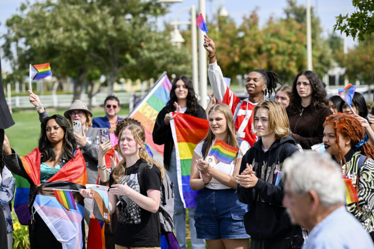 Students holding pride flags and trans flags gather at Pat Birdsall Sports Park across the street from Great Oak High School in Temecula, Calif., Friday, Sept. 22, 2023, after walking out of the school in protest of the Temecula school district policy requiring parents to be notified if their child identifies as transgender. (Anjali Sharif-Paul/The Orange County Register via AP)