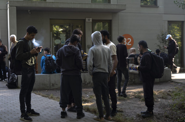 Dozens of people from all over the world line in front of the central registration center for asylum seekers in Berlin, Germany, Monday, Sept. 25, 2023. Across Germany, officials are sounding the alarm that they are no longer in a position to accommodate migrants who are applying for asylum. (AP Photo/Markus Schreiber)