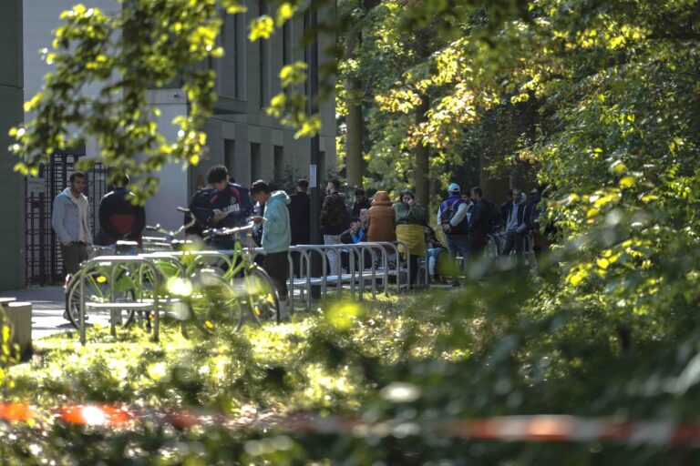 Dozens of people from all over the world line in front of the central registration center for asylum seekers in Berlin, Germany, Monday, Sept. 25, 2023. Across Germany, officials are sounding the alarm that they are no longer in a position to accommodate migrants who are applying for asylum. (AP Photo/Markus Schreiber)