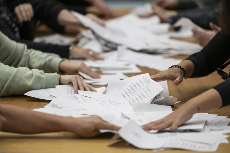 Stimmenzaehlerinnen und Stimenzaehler sortieren die Wahlzettel zur Nationalratswahl, am Tag der Eidgenoessischen Wahlen, am Sonntag, 22. Oktober 2023 in der Sporthalle Weissenstein in Bern. Die Schweizer Buergerinnen und Buerger waehlen das Bundesparlament mit den beiden Kammern Nationalrat und Staenderat. (KEYSTONE/Alessandro della Valle)