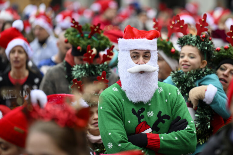 Runners dressed in Santa Claus costumes take part in the 16th edition of the Christmas Run in Lausanne, Switzerland, Sunday, December 17, 2023. More than 500 runners, dressed up as a Christmas figure participated (in two categories Santa Claus and Family) in 1.8 and 2.4 kilometer (1.1 and 1.5 miles) run through the old part of the city of Lausanne, in western Switzerland. (KEYSTONE/Laurent Gillieron)