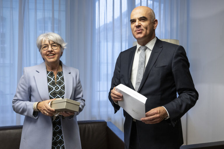 Bundespraesident Alain Berset, rechts, und seine Nachfolgerin Bundesraetin Elisabeth Baume-Schneider tauschen Geschenke aus, am Freitag, 22. Dezember 2023, in Bern. (KEYSTONE/Peter Schneider)