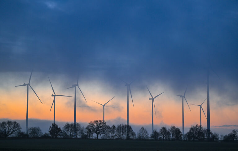ARCHIV - 15.12.2023, Brandenburg, Sieversdorf: Der Morgenhimmel leuchtet über dem Windenergiepark «Odervorland», während Nebel und dichte Wolken über die Landschaft ziehen. (zu dpa «Anteil der Erneuerbaren an Stromerzeugung wächst auf über die Hälfte») Foto: Patrick Pleul/dpa +++ dpa-Bildfunk +++ (KEYSTONE/DPA/Patrick Pleul)