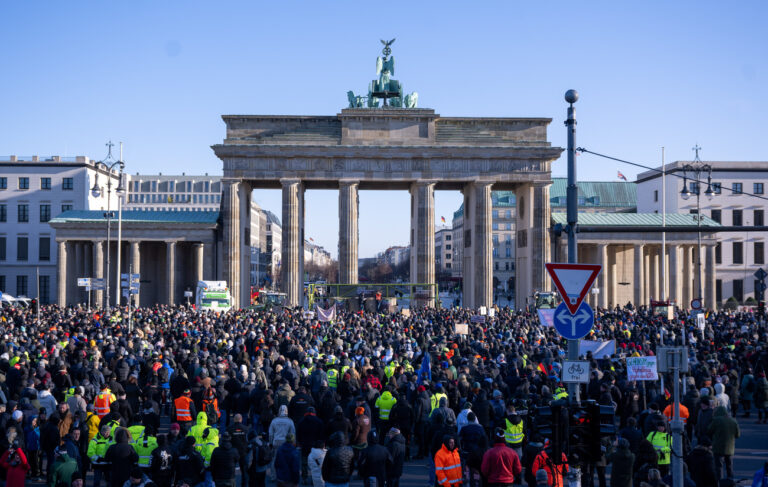 08.01.2024, Berlin: Zahlreiche Menschen stehen bei der Kundgebung des Verbands der Freien Bauern gegen die Subventionskürzungen in der Agrarwirtschaft vor dem Brandenburger Tor. Als Reaktion auf die Sparpläne der Bundesregierung hat der Bauernverband zu einer Aktionswoche mit Kundgebungen und Sternfahrten ab dem 8. Januar aufgerufen. Sie soll am 15. Januar in einer Großdemonstration in der Hauptstadt gipfeln. Foto: Monika Skolimowska/dpa +++ dpa-Bildfunk +++ (KEYSTONE/DPA/Monika Skolimowska)