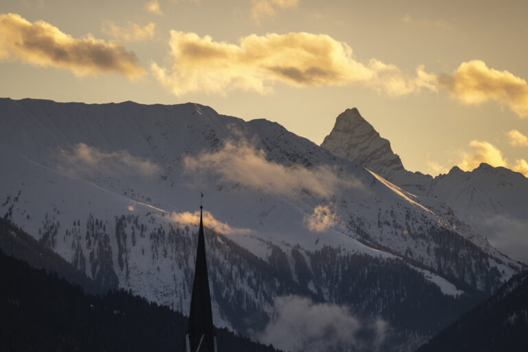 The Tinzenhorn mountain and churchtower of Davos, pictured during sunset on the eve of the 54th annual meeting of the World Economic Forum, WEF, in Davos, Switzerland, Monday, January 15, 2024. The meeting brings together entrepreneurs, scientists, corporate and political leaders in Davos under the topic 