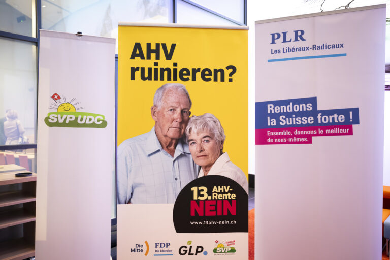 Ein Plakat des Nein-Komitee zur 13. AHV-Rente haengt neben einem FDP Plakat, kurz vor einer Medienkonferenz des ueberparteilichen Nein-Komitees zur 13. AHV-Rente in Bern, am Dienstag, 23. Januar 2024. (KEYSTONE/Anthony Anex)