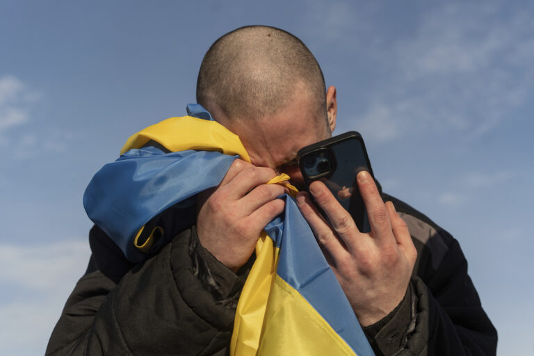 A recently swapped Ukrainian prisoner of war cries while calling his relatives after a prisoner exchange on the Ukrainian Russian border, on Wednesday, Jan. 31, 2024. Russia and Ukraine have exchanged about 200 prisoners of war each, the countries said Wednesday, despite tensions stemming from last week's crash of a military transport plane that Moscow claimed was carrying Ukrainian POWs and was shot down by Kyiv's forces. (AP Photo/Danylo Pavlov)