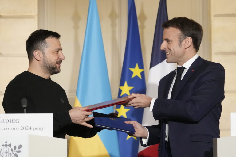 epa11159268 French President Emmanuel Macron (R) and his Ukrainian counterpart Volodymyr Zelensky exchange documents after signing an agreement at the Elysee Palace in Paris, France, 16 February 2024. French President Emmanuel Macron will sign a bilateral security agreement with his Ukrainian counterpart, Volodymyr Zelensky to provide 'long-term support' to the war-ravaged country which has been battling Russia's full-scale invasion for nearly two years. EPA/THIBAULT CAMUS / POOL MAXPPP OUT