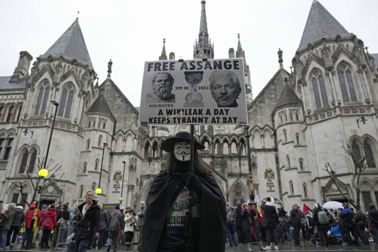 A protester stands outside the Royal Courts of Justice in London, Wednesday, Feb. 21, 2024. Julian Assange's lawyers are on their final U.K. legal challenge to stop the WikiLeaks founder from being sent to the United States to face spying charges. The 52-year-old has been fighting extradition for more than a decade, including seven years in self-exile in the Ecuadorian Embassy in London and the last five years in a high-security prison. (AP Photo/Kin Cheung)