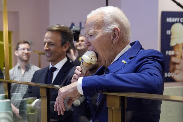 President Joe Biden eats ice cream at Van Leeuwen Ice Cream Monday, Feb. 26, 2024, in New York, as Seth Meyers watches. (AP Photo/Evan Vucci)