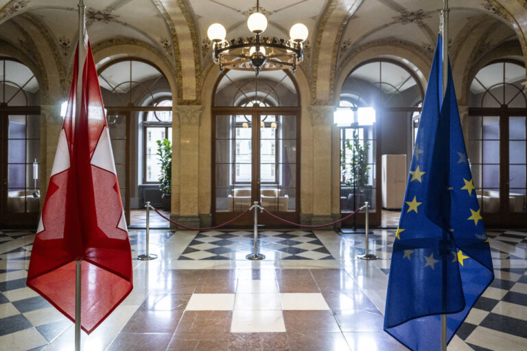 A Swiss, left, and a EU flag stand in the government building during the courtesy visit from Didier Reynders, European Commissioner for Justice, in Bern, Switzerland, on Thursday, March 7, 2024. (KEYSTONE/Peter Schneider)