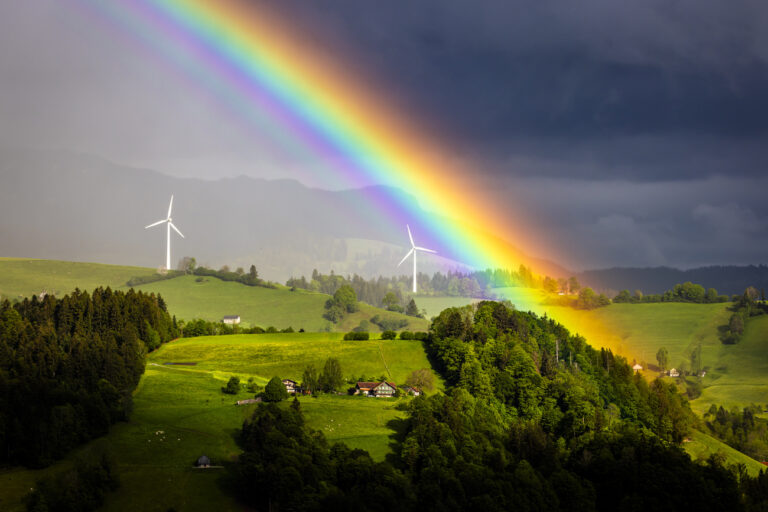 A rainbow arcs above two wind turbines on the Alp Lutersarni, left, and Feldmoos on the Rengg pass, in the village of Entlebuch in the UNESCO Biosphere Entlebuch, central Switzerland on Tuesday, May 21, 2024. On Sunday, June 9, 2024, the Swiss population will vote on the Electricity Supply Act on a secure electricity supply from renewable energies.(KEYSTONE/Michael Buholzer)
