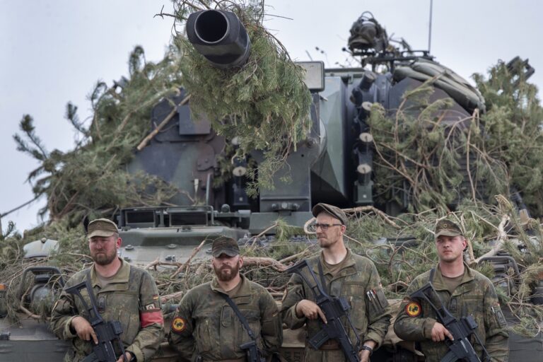 German Bundeswehr soldiers stand next to a self-propelled howitzer PzH 2000 of German Army during the Lithuanian-German division-level international military exercise 'Grand Quadriga 2024' at a training range in Pabrade, north of the capital Vilnius, Lithuania on Wednesday, May 29, 2024. 'Grand Quadriga 2024', a wide-scale exercise of the German Bundeswehr that rehearses moving two divisions from the central part of Europe to eastern. Over 3 thousand German troops and military equipment has been moved to Lithuania. (AP Photo/Mindaugas Kulbis)