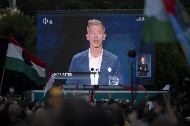 People listen to the speech of Peter Magyar during the debate in Budapest, Thursday May 30, 2024, ahead of the European Parliament elections, The debate, where the leaders of 11 party lists running in the June 9 elections, is the first to be broadcast by Hungary's public media since 2006, while protesters outside demonstrated against the public broadcaster that is hosting the event. (AP Photo/Denes Erdos)