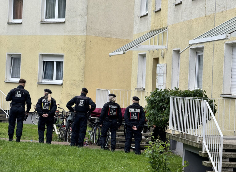 15.06.2024, Sachsen-Anhalt, Wolmirstedt: Polizisten stehen an einem Einsatzort, der möglichwerweise im Zusammenhang mit der Attacke in Wolmirstedt steht. Polizisten haben bei einem Einsatz in Wolmirstedt nördlich von Magdeburg am Freitagabend einen Mann erschossen. Dieser hat vorher die Beamten angegriffen, wie eine Polizeisprecherin am Samstagmorgen in Stendal sagte. Er starb den Angaben zufolge noch vor Ort. Foto: Thomas Schulz/dpa +++ dpa-Bildfunk +++ (KEYSTONE/DPA/Thomas Schulz)