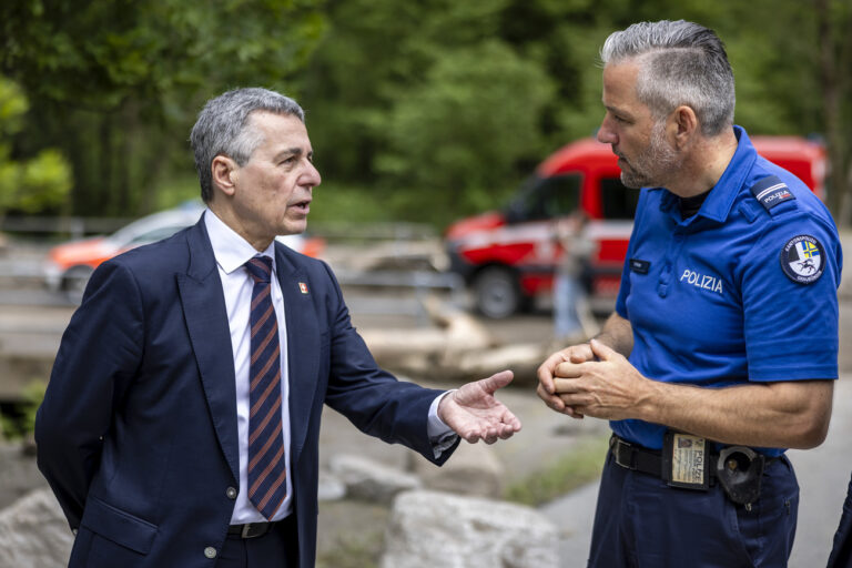 Swiss Federal Councillor Ignazio Cassis, left, speaks to William Kloter, commander of the Cantonal Police of Graubuenden, right, at the site of a landslide, caused by severe weather and heavy rain in the Misox valley, in Sorte village, Lostallo, southern Switzerland on Sunday June 23, 2024. Massive thunderstorms and rainfall led to a flooding situation with large-scale landslides on Friday evening in the Misox valley, south-eastern Switzerland. One person was found dead and two others were still missing on Sunday. (KEYSTONE/Michael Buholzer).