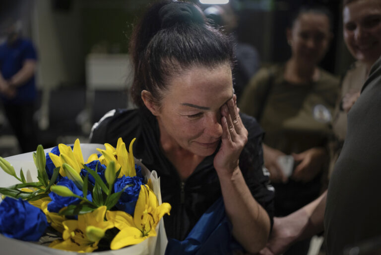 Olena Pekh, researcher at Horlivka Art Museum, cries while she speaks to her daughter via videosignal in Kyiv airport, Ukraine, Saturday, June 29, 2024. Ten Ukrainians who had been held prisoner for years were released from Russian captivity Friday with the mediation of the Vatican, Ukraine President Volodymyr Zelenskyy said. (AP Photo/Alex Babenko)