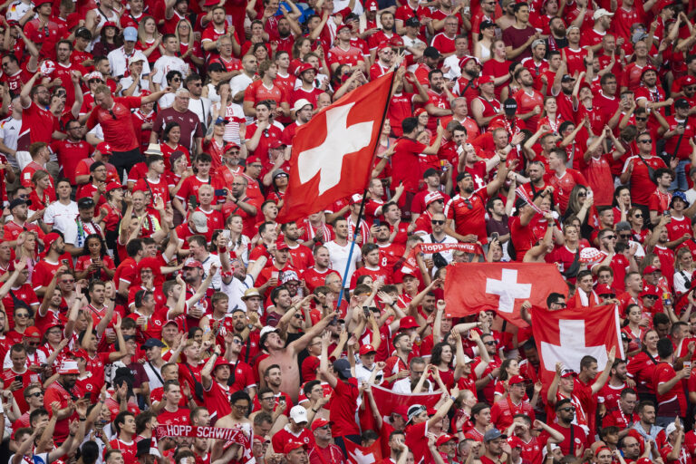 Swiss fans celebrate and wave their flags during a round of 16 match between Switzerland and Italy at the Euro 2024 soccer tournament in Berlin, Germany, Saturday, June 29, 2024. (KEYSTONE/Peter Klaunzer)