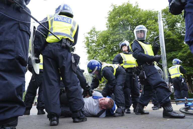 Police detain a man during an anti-immigration protest in Middlesbrough, England, Sunday Aug. 4, 2024. (Owen Humphreys/PA via AP)