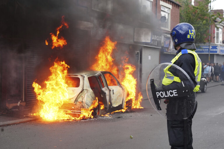 A car burns on Parliament Road during an anti-immigration protest in Middlesbrough, England, Sunday Aug. 4, 2024. (Owen Humphreys/PA via AP)