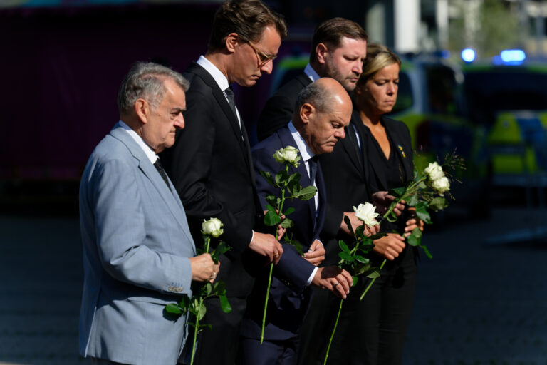 26.08.2024, Nordrhein-Westfalen, Solingen: Herbert Reul (CDU, l-r), Innenminister von Nordrhein-Westfalen, Hendrik Wüst (CDU), Ministerpräsident von Nordrhein-Westfalen, Bundeskanzler Olaf Scholz (SPD), Tim Kurzbach (SPD), Bürgermeister von Solingen, und Mona Neubaur (Grüne), stellvertretende Ministerpräsidentin von Nordrhein-Westfalen, legen weiße Rosen an einer Kirche in der Nähe des Tatorts ab. Bei einer Messerattacke auf der 650-Jahr-Feier der Stadt Solingen am 23. August hatte es drei Todesopfer und Verletzte gegeben. Foto: Henning Kaiser/dpa +++ dpa-Bildfunk +++ (KEYSTONE/DPA/Henning Kaiser)