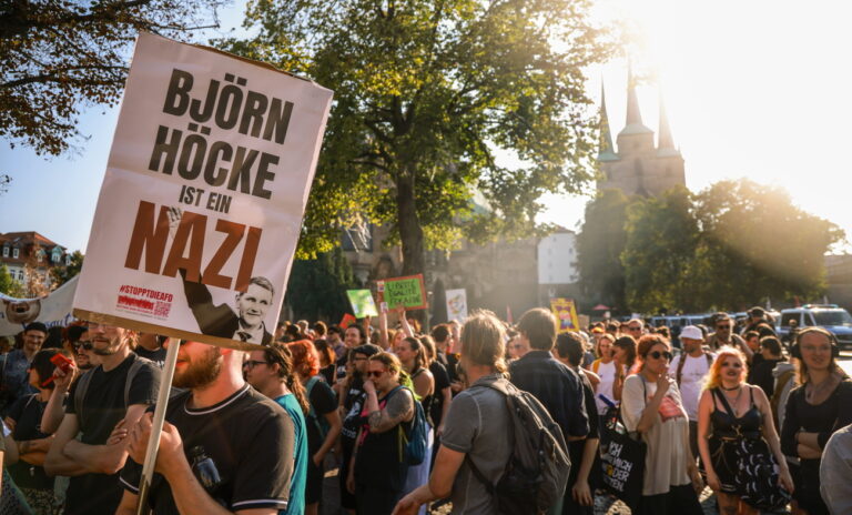 epa11575655 People hold a sign reading 'Bjoern Hoecke is a Nazi' at a counter protest during a far-right Alternative for Germany (AfD) party final campaign rally for the upcoming 2024 Thuringia state election, in Erfurt, Germany, 31 August 2024. Thuringia state election, voting for the regional parliament 'Landtag', will be held on 01 September 2024. EPA/CLEMENS BILAN