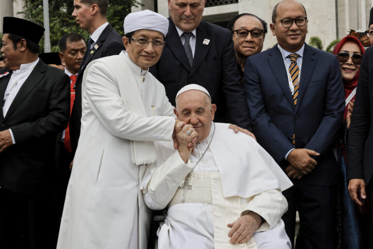 Pope Francis, center, kisses the right hand of the Grand Imam of Istiqlal Mosque Nasaruddin Umar during a family photo following an interreligious meeting with religious leaders at the Istiqlal Mosque in Jakarta, Thursday, Sept. 5, 2024. (KEYSTONE/Yasuyoshi Chiba/Pool Photo via AP)