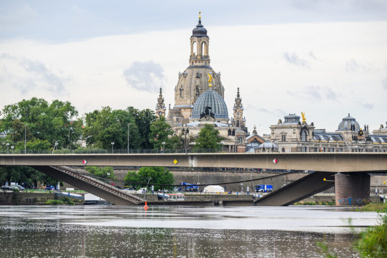 12.09.2024, Sachsen, Dresden: Blick auf die in Teilen eingestürzte Carolabrücke über die Elbe vor der Kulisse der Altstadt mit der Frauenkirche. Am Tag nach dem Teileinsturz der Carolabrücke laufen die Sicherungsarbeiten an dem Bauwerk. In der vergangenen Nacht ist auf der Seite der Dresdner Neustadt ein Unterbau fertiggestellt worden, der die Brücke am Übergang aufs Festland stützen soll. Foto: Robert Michael/dpa +++ dpa-Bildfunk +++ (KEYSTONE/DPA/Robert Michael)