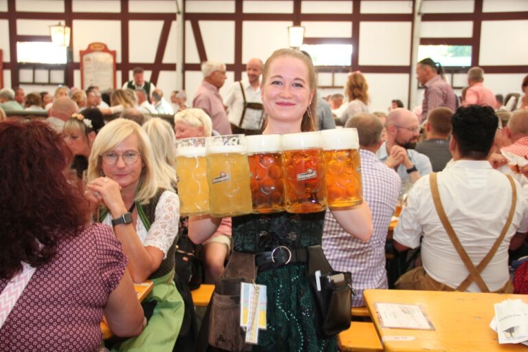 PRODUKTION - 07.09.2024, Sachsen, Plauen: Katharina Höhn serviert mehrere Maßkrüge bei der «Sternquell-Wiesn» in Plauen. (zu dpa: «Feiern in Dirndl und Lederhose - Oktoberfeste in Sachsen») Foto: Katrin Mädler/dpa-Zentralbild/dpa +++ dpa-Bildfunk +++ (KEYSTONE/DPA/Katrin Mädler)