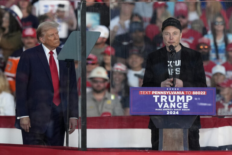 FILE - Republican presidential nominee former President Donald Trump listens as Elon Musk speaks during a campaign rally at the Butler Farm Show, Saturday, Oct. 5, 2024, in Butler, Pa. (AP Photo/Julia Demaree Nikhinson, File)