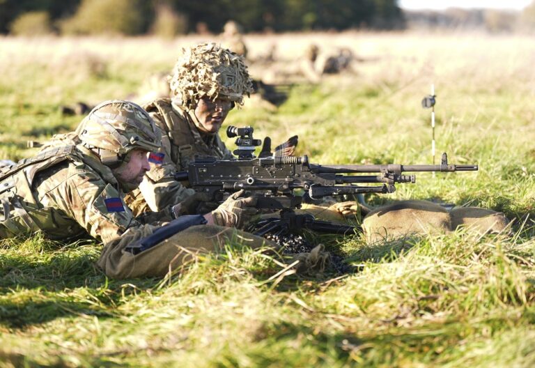 Britain's Prince William, the Prince of Wales and Colonel of the Welsh Guards, handles a general-purpose machine gun (GPMG), during a visit to the 1st Battalion Welsh Guards to hear how they have been transitioning from ceremonial duty back to the Field Army, at Salisbury Plain, in Wiltshire, England, Tuesday, Nov. 26, 2024. (Aaron Chown/Pool Photo via AP)