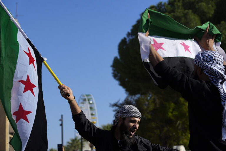 A Syrian man waves a flag during a spontaneous demonstration celebrating the fall of the Assad regime in Nicosia, Cyprus, Sunday, Dec. 8, 2024. (AP Photo/Petros Karadjias)