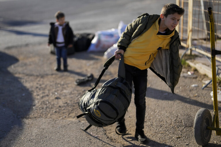 A Syrian boy carries a bag as he arrives to cross into Syria from Turkey at the Oncupinar border gate, near the town of Kilis, southern Turkey, Monday, Dec. 9, 2024. (AP Photo/Khalil Hamra)