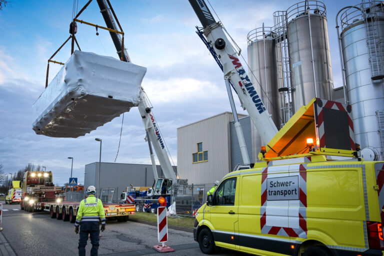 19.12.2024, Sachsen-Anhalt, Lutherstadt Eisleben: Ein 50 Tonnen schweres Teil eines neuen Ofen für die Aryzta Bakeries wird vom Tieflader in die Produktionshalle verbracht. Es ist Teil eines neuen 100 Tonnen schweren Ofens für eine neue Produktionslinie. Das Unternehmen ist Hersteller von Tiefkühlbackwaren. Foto: Heiko Rebsch/dpa +++ dpa-Bildfunk +++ (KEYSTONE/DPA/Heiko Rebsch)