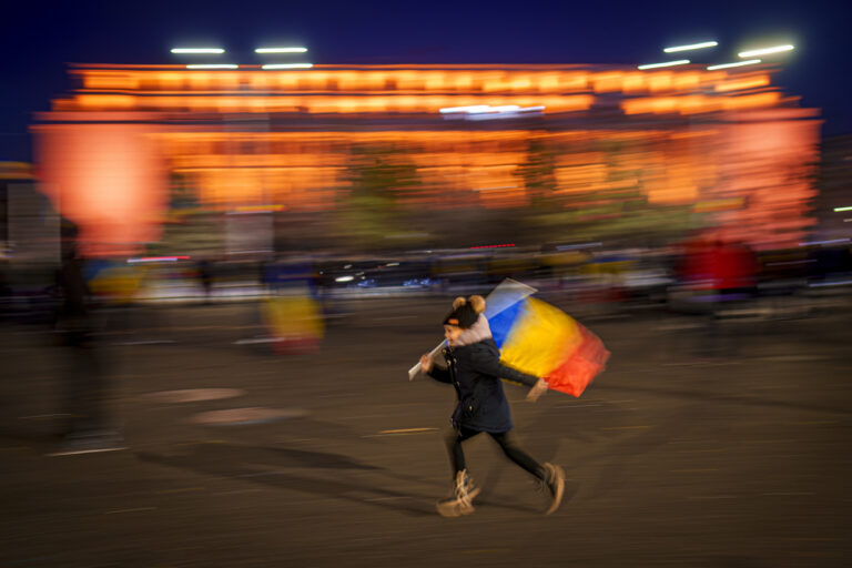 A child runs during a protest by supporters of Calin Georgescu, the winner of Romania's first round of presidential election, which the Constitutional Court later annulled, who broke through police lines and marched to the government headquarters, in Bucharest, Romania, Friday, Jan. 24, 2025.(AP Photo/Vadim Ghirda)