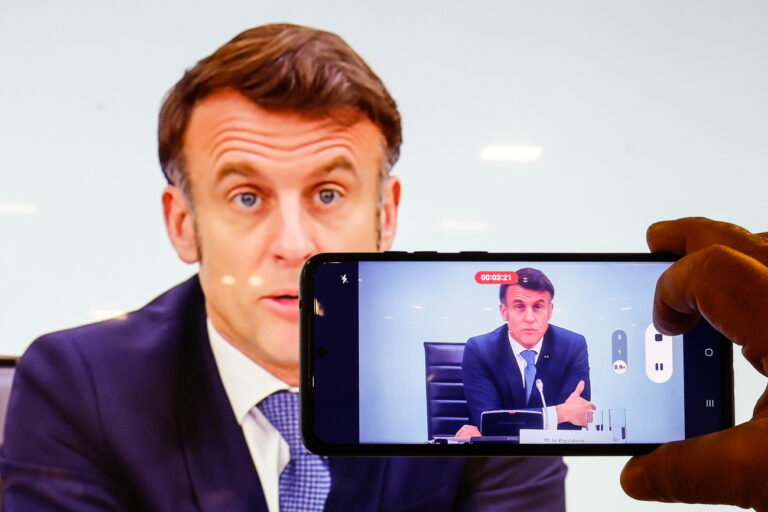 epa11894163 A man takes a photograph of a screen showing French President Emmanuel Macron as he speaks during the International Conference on Syria at the Ministerial Conference Center, in Paris, France, 13 February 2025 EPA/MOHAMMED BADRA